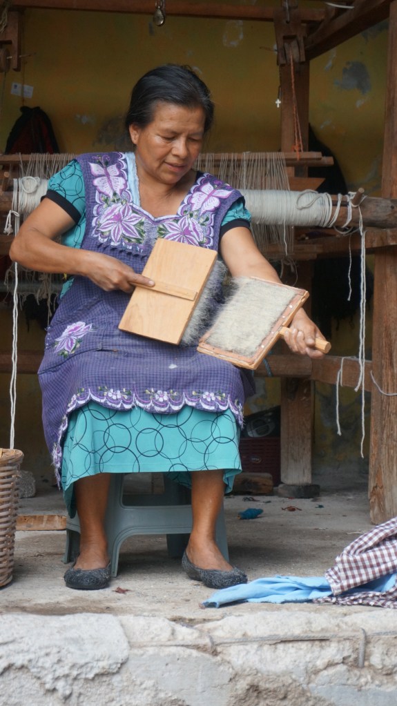 Learning just how challenging it is to card the wool - a real workout.