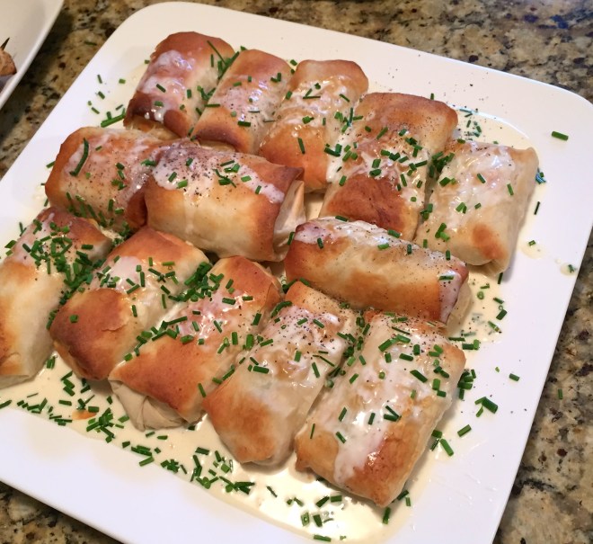 Ready for a party, these little phyllo packages are sprinkled with chives, fresh dill and an extra little drizzle of the lemon sauce.